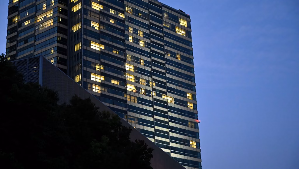 Office tower with its lit floors against a dusk sky